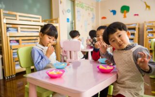 three toddler eating on white table